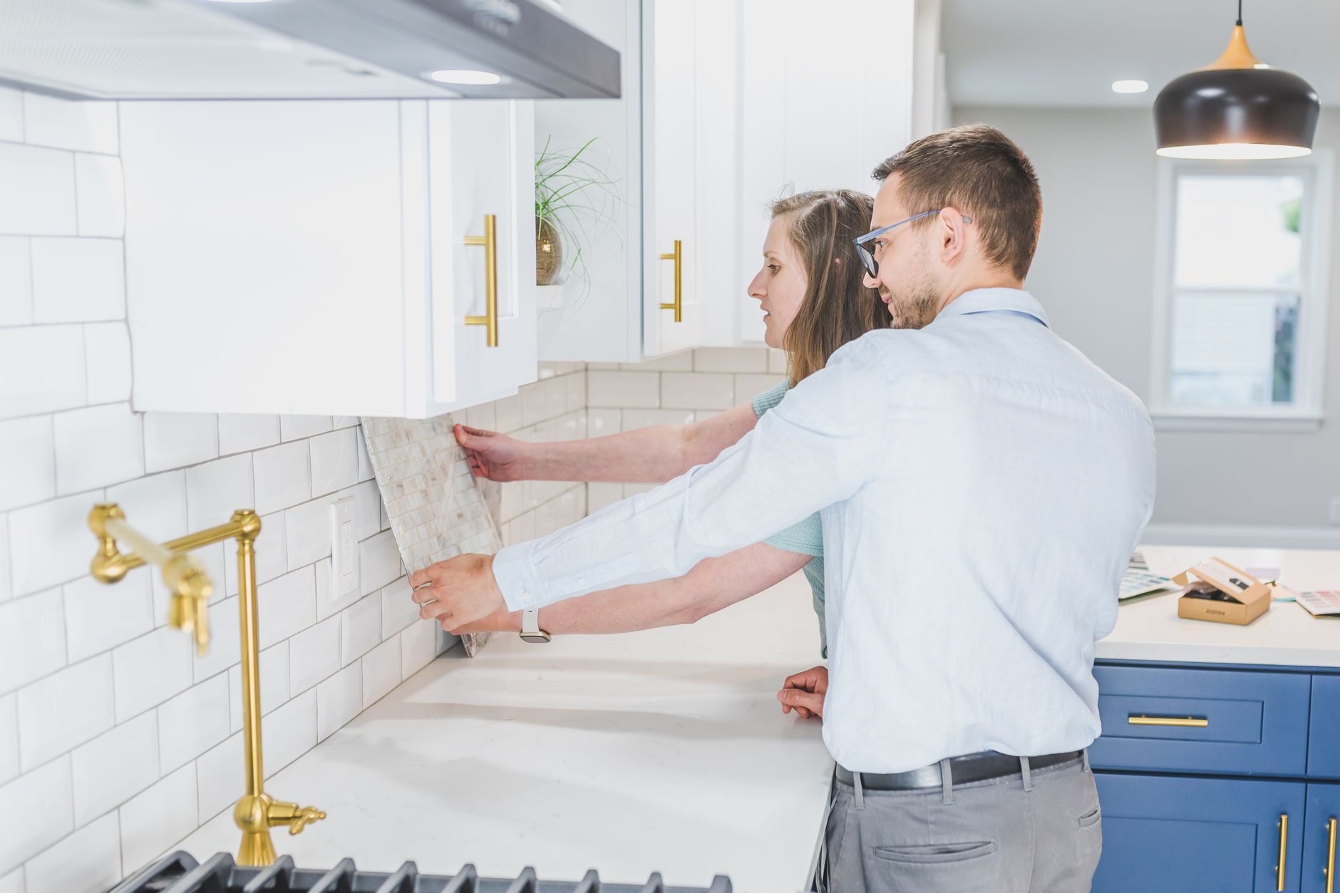 A couple examines backsplash tiles for their modern kitchen renovation in Bellevue, WA